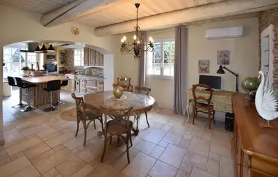 a kitchen and dining room with a table and chairs at Maison Avec Piscine Privée in Entraigues-sur-la-Sorgue