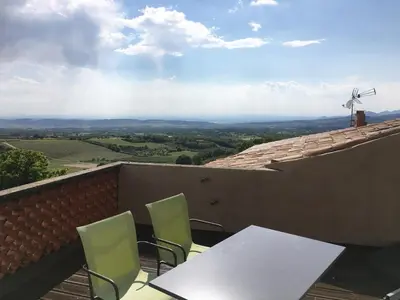 a table and chairs on a roof with a wind turbine at Maison Les Bruns, sur la route du Mont Ventoux in Bédoin