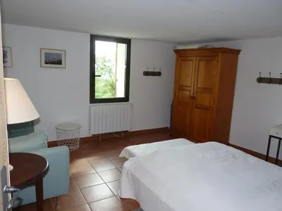 a bedroom with a bed and a desk and a window at Maison Les Bruns, sur la route du Mont Ventoux in Bédoin