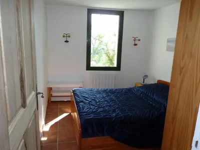 a bedroom with a blue bed and a window at Maison Les Bruns, sur la route du Mont Ventoux in Bédoin