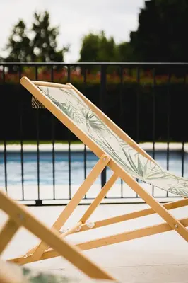 a wooden chair sitting on top of a balcony at Le mas des cerisiers - piscine chauffée in Caumont-sur-Durance