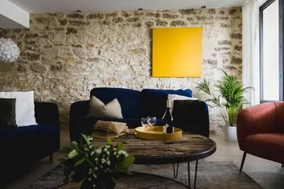a living room with a blue couch and a table at Le mas des cerisiers - piscine chauffée in Caumont-sur-Durance