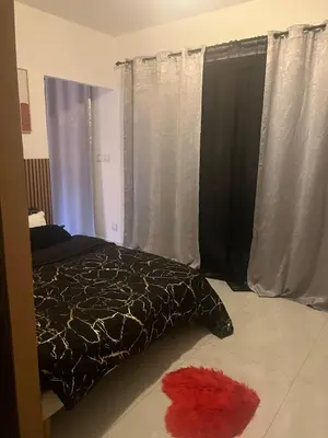 a bedroom with a bed and a red carpet at Appartement cosy & calme avec parking privé & terrasse in Mazan
