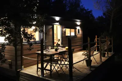 a tiny house with a table and chairs on a deck at Tiny House Sainte Victoire - Brasserie Aix Pression in Rognes