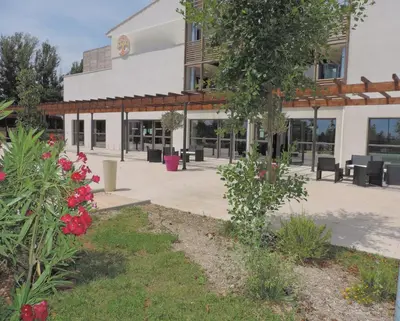 a building with tables and chairs in front of it at Studios Nuitée en Provence in Aix-en-Provence