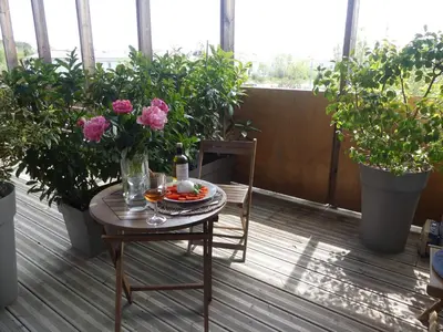 a table and chairs on a balcony with potted plants at Studios Nuitée en Provence in Aix-en-Provence