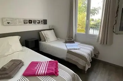 a bedroom with two beds and a window at Les terrasses di Matt et eaux in LʼIsle-sur-la-Sorgue