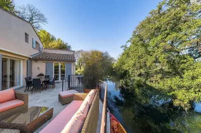 a house with a balcony with a view of a river at Les terrasses di Matt et eaux in LʼIsle-sur-la-Sorgue