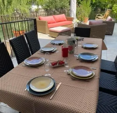 a table with plates and wine glasses on a patio at Les terrasses di Matt et eaux in LʼIsle-sur-la-Sorgue