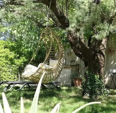 a hammock hanging from a tree in a yard at Les terrasses di Matt et eaux in LʼIsle-sur-la-Sorgue