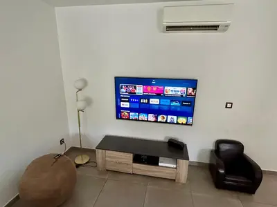 a living room with a flat screen tv on a wall at Modern City Center apartment with parking! in Aix-en-Provence