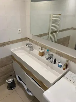 a white speaker sitting on top of a wooden table at Modern City Center apartment with parking! in Aix-en-Provence