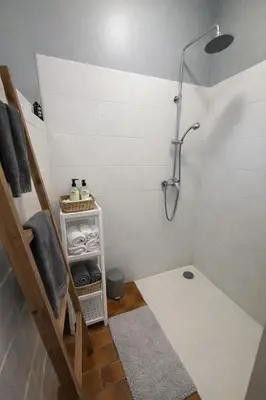 a bathroom with a shower and a shelf with towels at Mas Caumontois Provençal charm & private pool in Caumont-sur-Durance