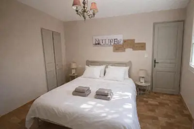 a bedroom with a white bed with towels on it at Mas Caumontois Provençal charm & private pool in Caumont-sur-Durance
