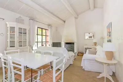 a white living room with a table and a couch at Provençal House With Pool Near Roussillon in Roussillon