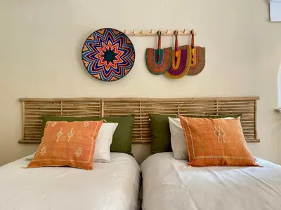 two beds with pillows and a plate on the wall at Provençal Villa At Domaine in Cornillon-Confoux