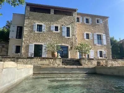 a building on the water in front of a building at Five-Bedroom Estate Above Ménerbes Village in Ménerbes