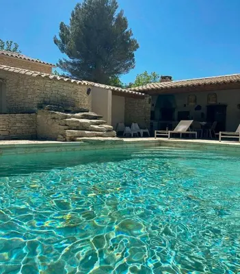 a pool of water in front of a house at Family Stone House In Gordes in Gordes