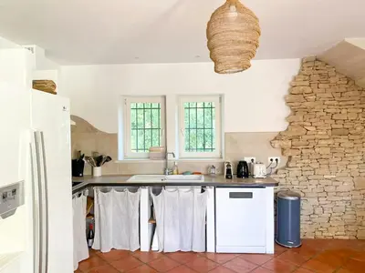 a kitchen with white appliances and a stone wall at Family Stone House In Gordes in Gordes