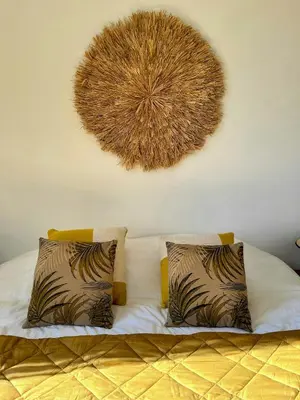 a bed with two pillows and a decoration on the wall at Family Stone House In Gordes in Gordes
