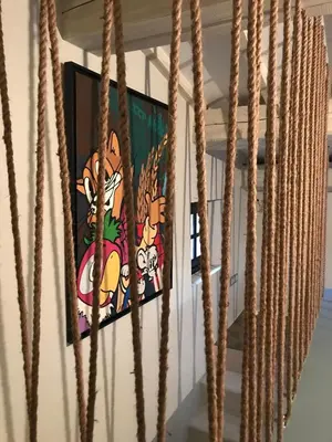 a painting on the wall in a room with ropes at L'ISLE SUR LA SORGUE - Maison de prestige in Saumane-de-Vaucluse