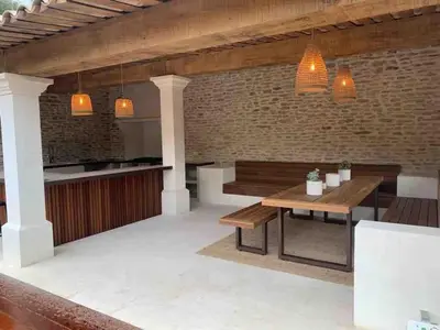 a patio with a wooden bench and a table at L'ISLE SUR LA SORGUE - Maison de prestige in Saumane-de-Vaucluse