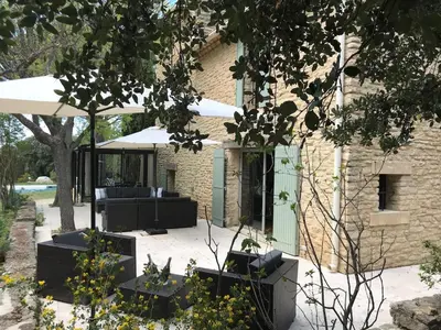 a patio with black furniture in front of a building at L'ISLE SUR LA SORGUE - Maison de prestige in Saumane-de-Vaucluse