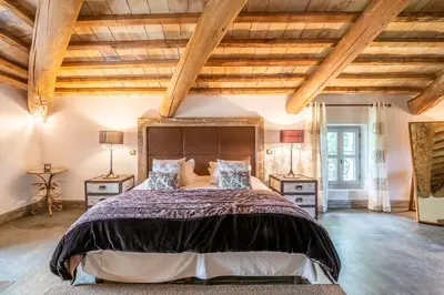 a bedroom with a large bed and wooden ceilings at Wine Estate With Sunset Courtyard Near Bédoin in Mazan