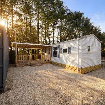 a white tiny house with a porch and a deck at Mobile Home Pro - 4 personnes et parking in Pélissanne