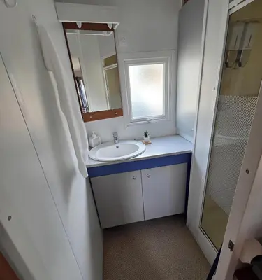 a bathroom with a sink and a window and a mirror at Mobile Home Pro - 4 personnes et parking in Pélissanne