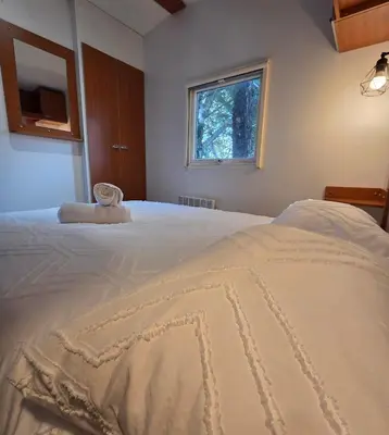 a bedroom with a large white bed with a window at Mobile Home Pro - 4 personnes et parking in Pélissanne