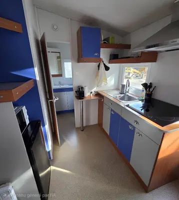 a small kitchen with blue cabinets and a sink at Mobile Home Pro - 4 personnes et parking in Pélissanne
