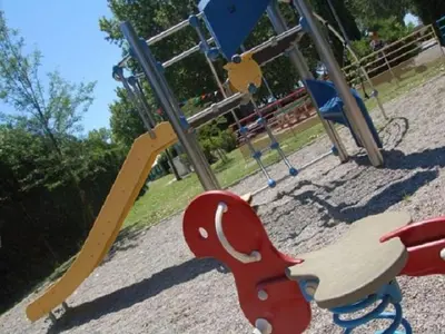 a park with a playground with a slide and a wooden horse swing at Mobil Home PMR avec Terrasse à Cavaillon - API-1-52-1378 in Cavaillon