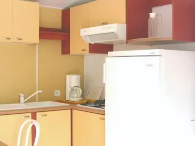 a kitchen with a white refrigerator and a stove at Mobil-home 32m² avec terrasse, 3 chambres à Cavaillon, 8 pers. - API-1-52-1384 in Cavaillon