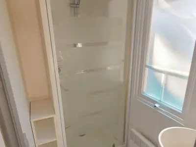 a glass shower in a bathroom with a window at Mobil-home confortable, 2 chambres, 4 personnes - API-1-52-1390 in Cavaillon