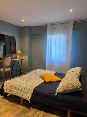 a bedroom with a bed with a blue wall at Splendid Loft in Provence in Robion en Luberon