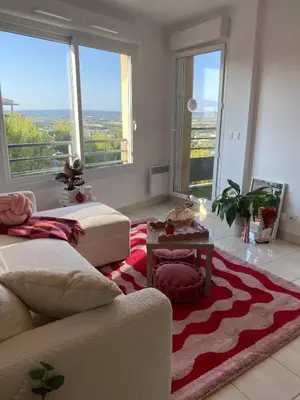 a living room with a couch and a red and white rug at Happy appartement in Aix-en-Provence