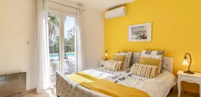 a bedroom with a large bed with a yellow wall at Villa Peyriere-Ventoux in Carpentras