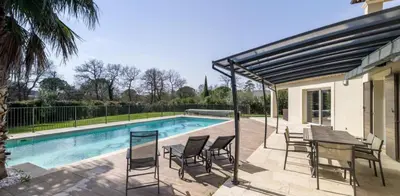 a patio with a table and chairs next to a pool at Villa Peyriere-Ventoux in Carpentras