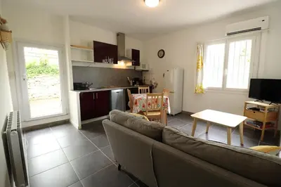 a living room with a couch and a kitchen at Gîte Le Relais à Mazan in Mazan