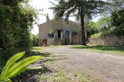 an old stone house with a tree in front of it at Gîte Le Relais à Mazan in Mazan