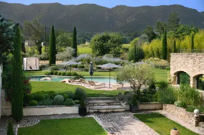 a garden with a swimming pool and mountains in the background at 19Th-Century Mas With Pool And Garden Facing Luberon in Oppède