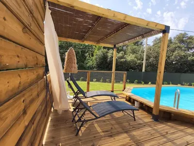 a deck with a chair and an umbrella and a pool at New Villa in Provence La Modèna in Modène