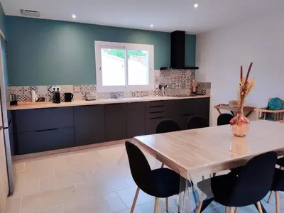 a kitchen with a wooden table and black cabinets at New Villa in Provence La Modèna in Modène