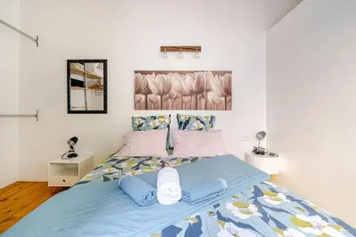 a bedroom with a large bed with blue sheets at Charmante maison de village avec cour intérieure in Bédoin
