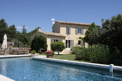 a house with a swimming pool in front of a house at La Maison des Restanques in Cabrières-dʼAvignon