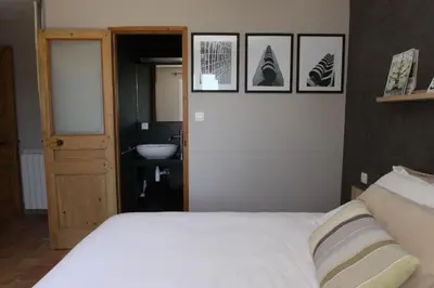 a bedroom with a white bed and a sink at La Maison des Restanques in Cabrières-dʼAvignon