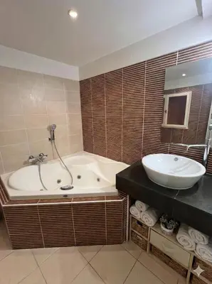 a bathroom with a tub and a sink at Maison de ville climatisée avec toit-terrasse privatif in Monteux