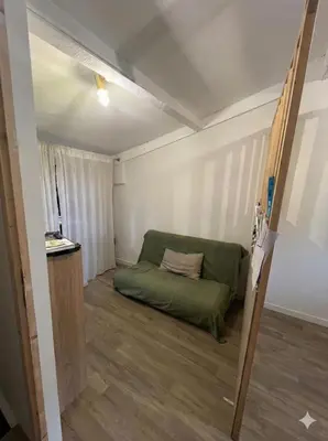 a small room with a green couch in it at Maison de ville climatisée avec toit-terrasse privatif in Monteux