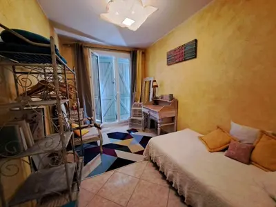 a bedroom with a bed and a desk and a window at Rooms with sculptor in Pinèdes in Aurons